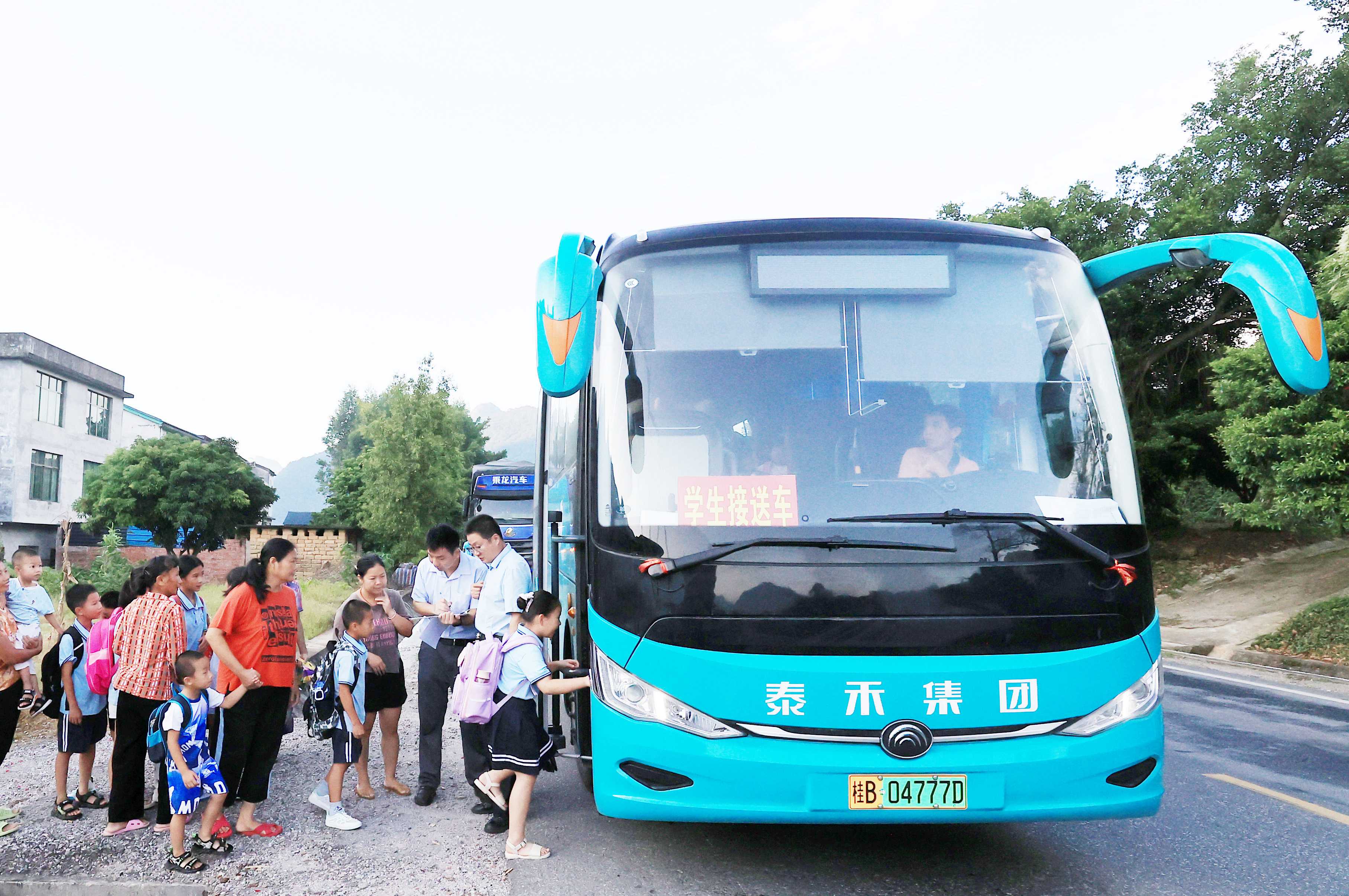 圖2：9月2日早晨，在廣西柳州市融安縣浮石鎮諫村村，工作人員在核對乘車人員名單，準備送學生去學校讀書。（譚凱興 攝）.JPG