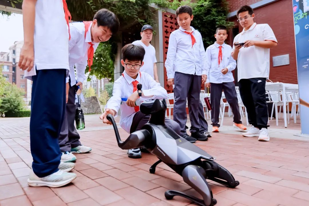 學(xué)生與人工智能機(jī)器狗互動。學(xué)校供圖.jpg